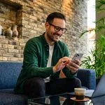 Beginner investor checking investing app on smartphone at home